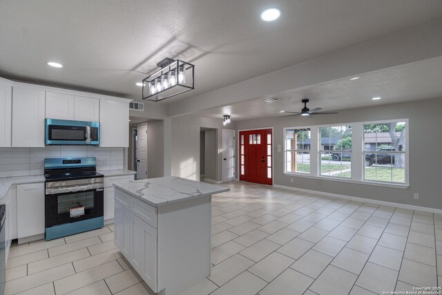 206 Scott, Universal City, TX 78148 - kitchen with appliances with stainless steel finishes, open floor plan, recessed lighting, white cabinets, and light tile patterned floors