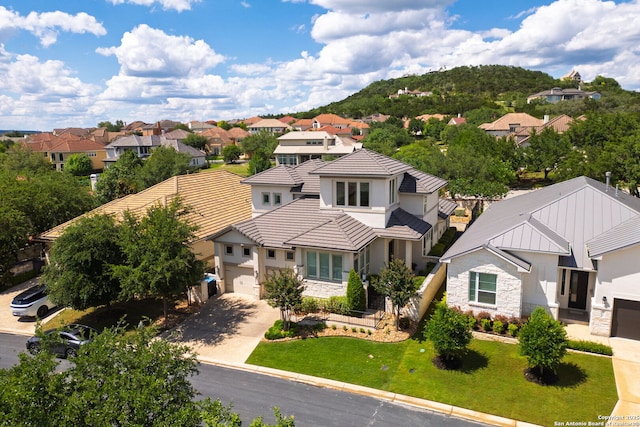 17 Denbury, San Antonio, TX 78257 - view of front of house featuring a residential view, concrete driveway, a tiled roof, and stone siding