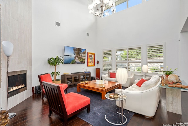 17 Denbury, San Antonio, TX 78257 - living room featuring a towering ceiling, wood finished floors, a tiled fireplace, a chandelier, and plenty of natural light