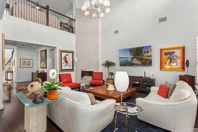 17 Denbury, San Antonio, TX 78257 - living room featuring a towering ceiling, wood finished floors, a tiled fireplace, a chandelier, and stairs