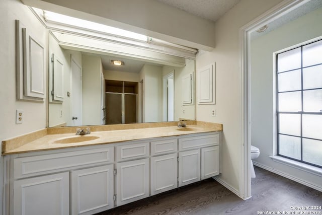 2514 Silver Rdg, San Antonio, TX 78232 - bathroom with toilet, double vanity, wood finished floors, and plenty of natural light
