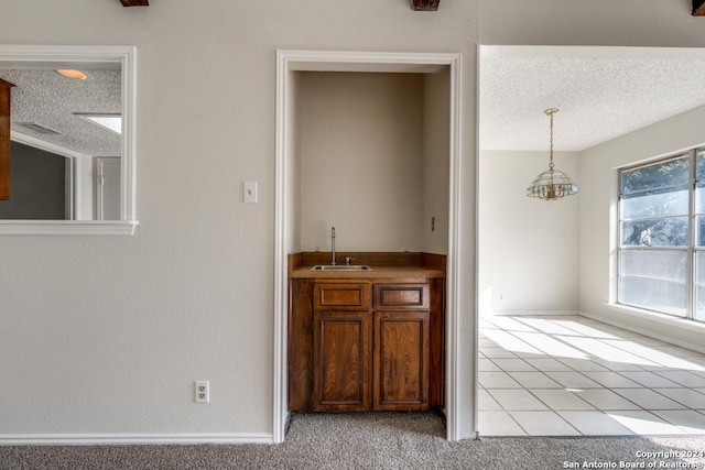2514 Silver Rdg, San Antonio, TX 78232 - indoor wet bar featuring a textured ceiling, pendant lighting, a chandelier, and baseboards