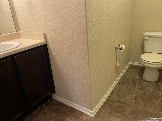 12242 Bening Vly, Schertz, TX 78154 - bathroom featuring a textured wall, vanity, toilet, and baseboards
