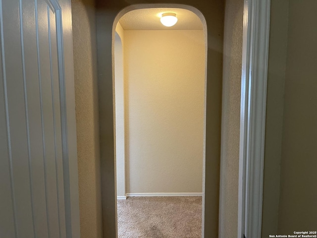 12242 Bening Vly, Schertz, TX 78154 - hall featuring carpet floors, arched walkways, baseboards, and a textured wall