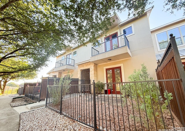 4171 Texas Elm, San Antonio, TX 78230 - back of property with a balcony, french doors, stucco siding, a fenced front yard, and stone siding