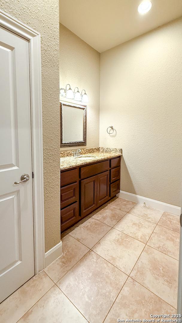 4171 Texas Elm, San Antonio, TX 78230 - bathroom featuring vanity, baseboards, tile patterned floors, recessed lighting, and a textured wall