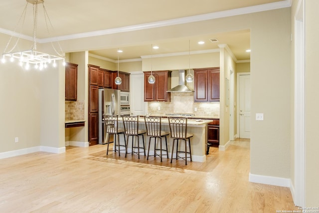 4171 Texas Elm, San Antonio, TX 78230 - kitchen featuring wall chimney range hood, appliances with stainless steel finishes, a kitchen breakfast bar, tasteful backsplash, and pendant lighting