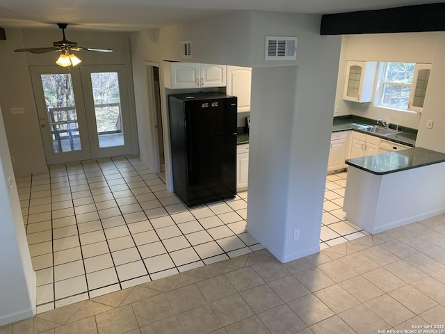 1076 Eastview, Canyon Lake, TX 78133 - kitchen featuring freestanding refrigerator, a sink, dark countertops, light tile patterned floors, and white cabinets