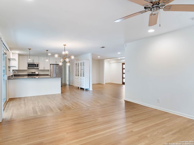602 Northridge, San Antonio, TX 78209 - unfurnished living room with a ceiling fan, light wood-style flooring, a chandelier, baseboards, and recessed lighting