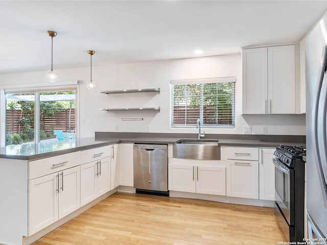 602 Northridge, San Antonio, TX 78209 - kitchen featuring stainless steel appliances, a sink, dark countertops, a peninsula, and open shelves