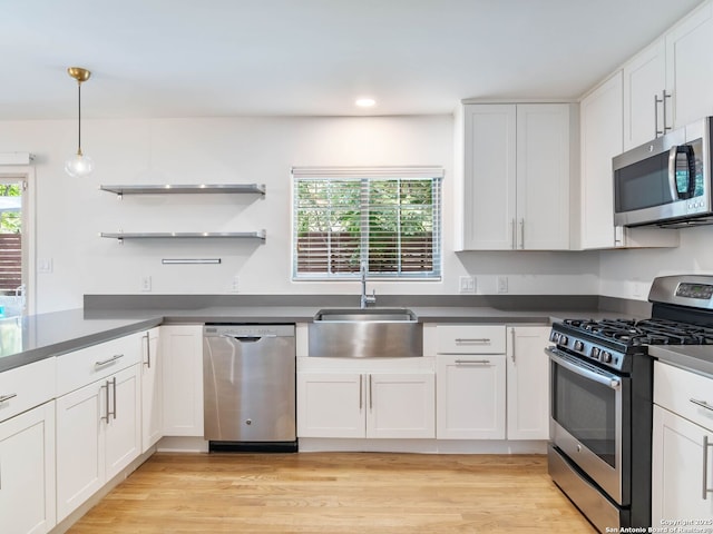 602 Northridge, San Antonio, TX 78209 - kitchen featuring stainless steel appliances, a sink, white cabinets, dark countertops, and decorative light fixtures