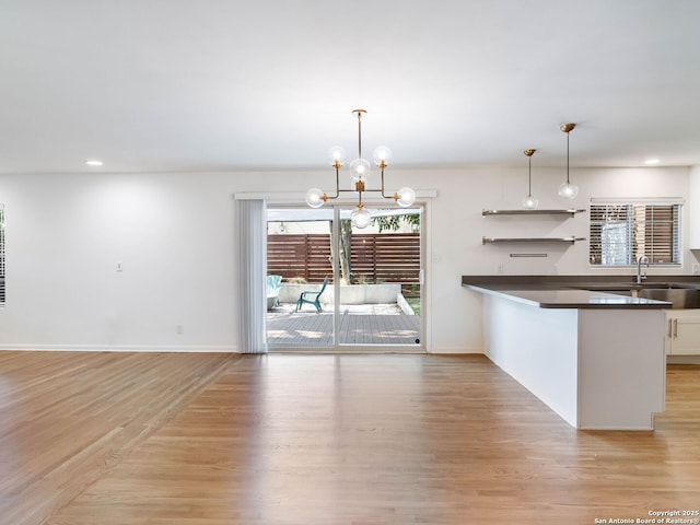 602 Northridge, San Antonio, TX 78209 - kitchen featuring dark countertops, light wood-style flooring, pendant lighting, recessed lighting, and a chandelier