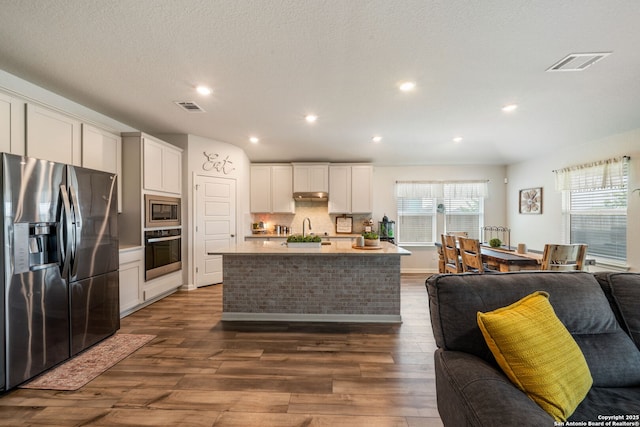 948 Black Horse Way, San Antonio, TX 78260 - kitchen featuring stainless steel appliances, open floor plan, dark wood-style flooring, backsplash, and a kitchen island with sink