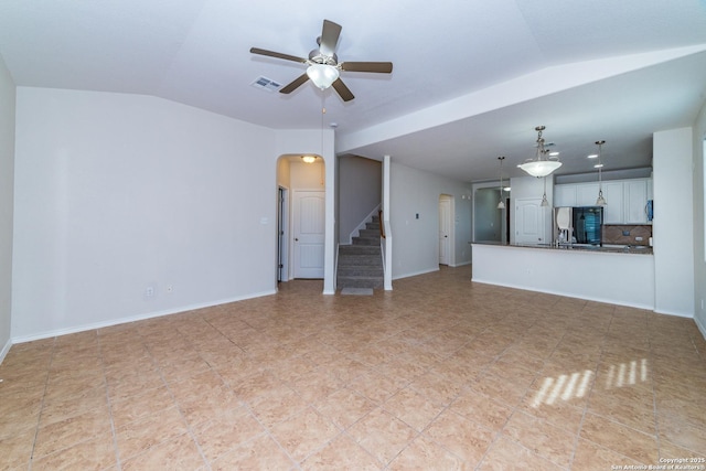 7735 Brisbane Bnd, Converse, TX 78109 - unfurnished living room featuring lofted ceiling, a ceiling fan, stairs, arched walkways, and baseboards