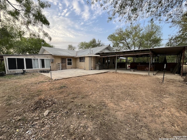 512 Brown Ln, Floresville, TX 78114 - rear view of property featuring a patio area, metal roof, an attached carport, and a hot tub