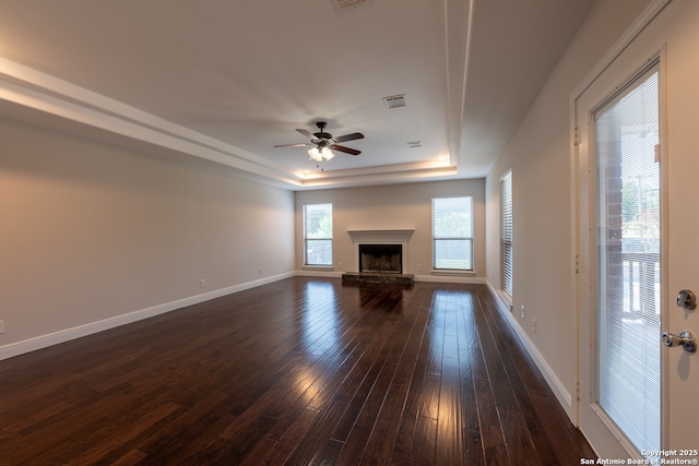 8718 Paseo Oaks, San Antonio, TX 78255 - unfurnished living room with a tray ceiling, dark wood-type flooring, a ceiling fan, baseboards, and a fireplace with raised hearth