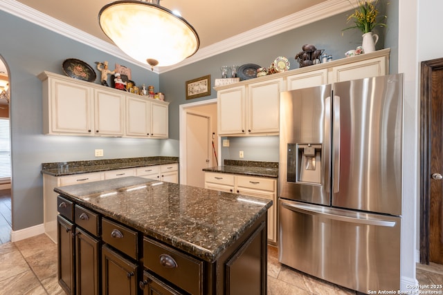 8718 Paseo Oaks, San Antonio, TX 78255 - kitchen featuring stainless steel fridge, cream cabinetry, arched walkways, dark stone counters, and crown molding