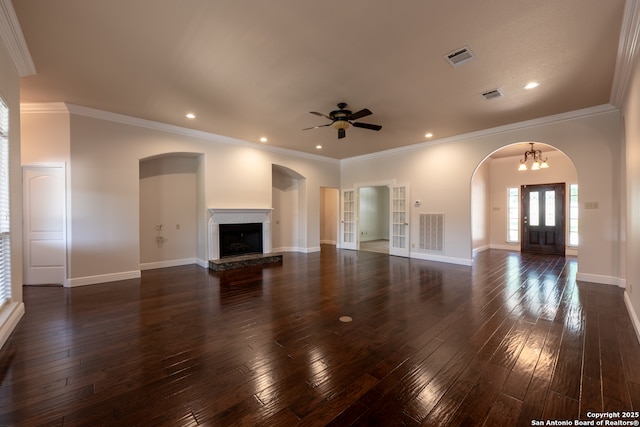 8718 Paseo Oaks, San Antonio, TX 78255 - unfurnished living room with dark wood finished floors, arched walkways, a fireplace with raised hearth, a ceiling fan, and crown molding