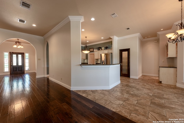 8718 Paseo Oaks, San Antonio, TX 78255 - kitchen with stainless steel fridge, a chandelier, arched walkways, dark countertops, and baseboards