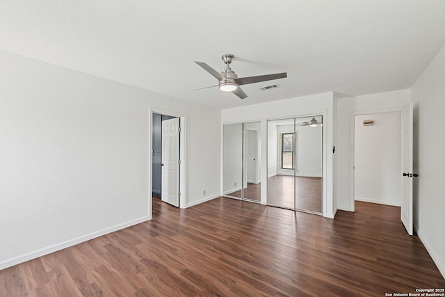 1312 Acorn, Hondo, TX 78861 - unfurnished bedroom with wood finished floors, two closets, baseboards, and a ceiling fan