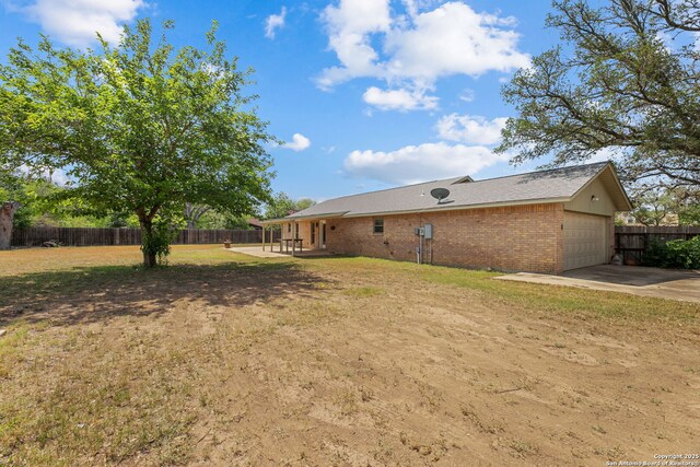 1312 Acorn, Hondo, TX 78861 - view of yard with a garage, concrete driveway, and a patio