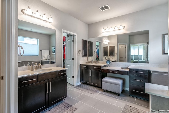 25514 Vista Bella, San Antonio, TX 78260 - full bathroom with healthy amount of natural light, two vanities, tile patterned flooring, and a textured wall