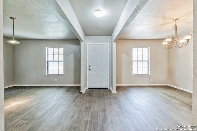 4203 Quail, San Antonio, TX 78217 - entryway featuring wood finished floors, baseboards, a textured ceiling, and a chandelier