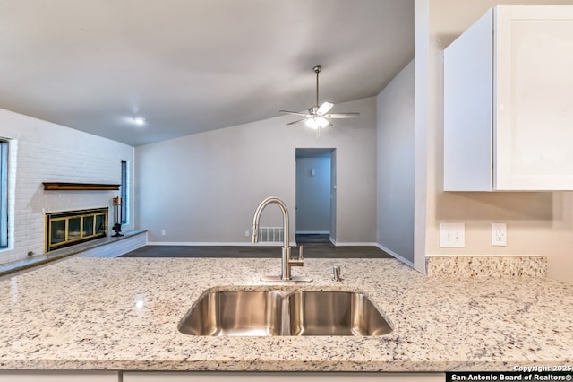 4203 Quail, San Antonio, TX 78217 - kitchen featuring a sink, lofted ceiling, white cabinets, open floor plan, and light stone counters