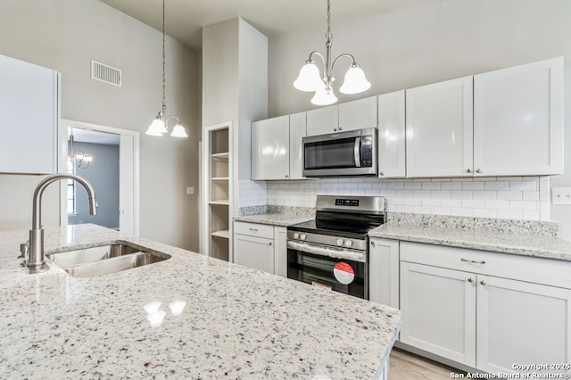 4203 Quail, San Antonio, TX 78217 - kitchen with stainless steel appliances, a chandelier, a sink, tasteful backsplash, and light stone counters