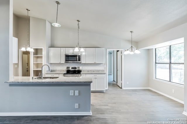 4203 Quail, San Antonio, TX 78217 - kitchen featuring appliances with stainless steel finishes, a chandelier, a sink, backsplash, and white cabinetry