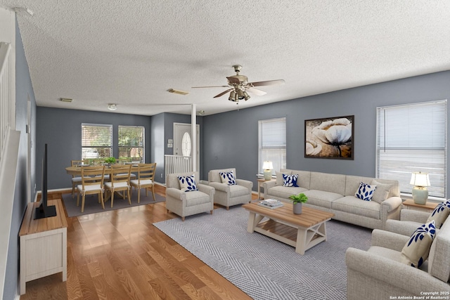 8134 Cheryl Mdw, Converse, TX 78109 - living room featuring wood finished floors, a ceiling fan, and a textured ceiling
