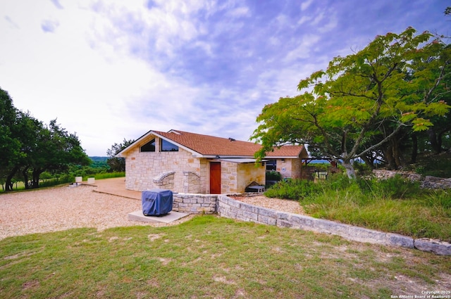 1231 Montell, Wimberley, TX 78676 - view of property exterior featuring stone siding and a lawn