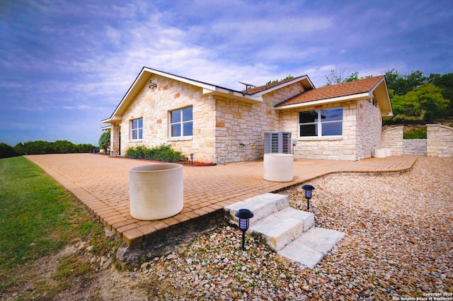 1231 Montell, Wimberley, TX 78676 - rear view of property featuring stone siding, a patio area, and central AC unit