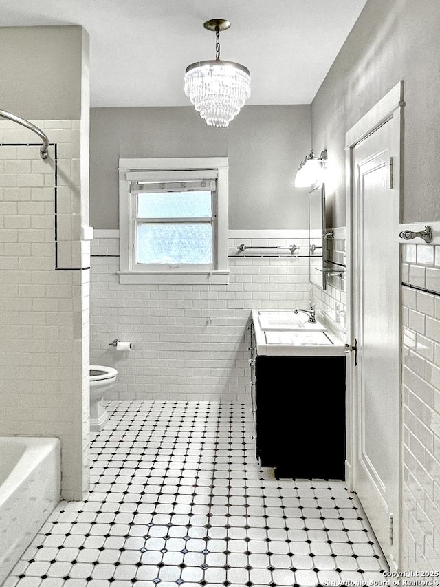 436 W Gramercy Pl, San Antonio, TX 78212 - full bathroom with tile walls, toilet, vanity, wainscoting, and a chandelier