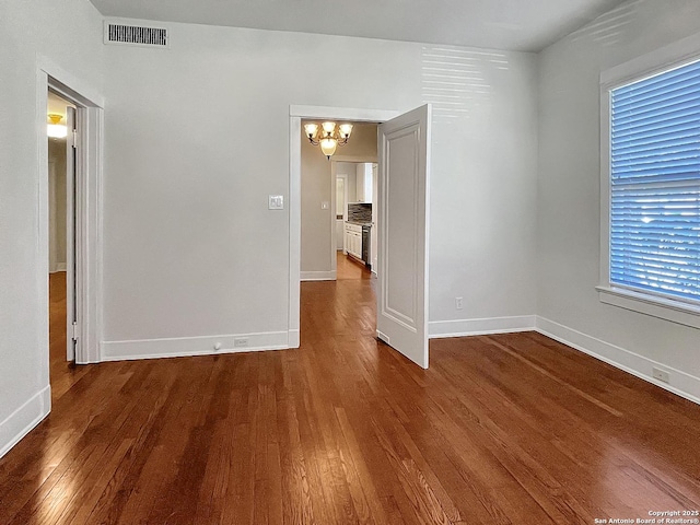 436 W Gramercy Pl, San Antonio, TX 78212 - unfurnished room with a chandelier, dark wood-type flooring, and baseboards