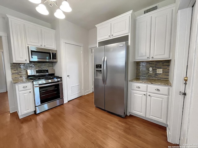 436 W Gramercy Pl, San Antonio, TX 78212 - kitchen featuring appliances with stainless steel finishes, decorative backsplash, light wood-type flooring, and white cabinetry