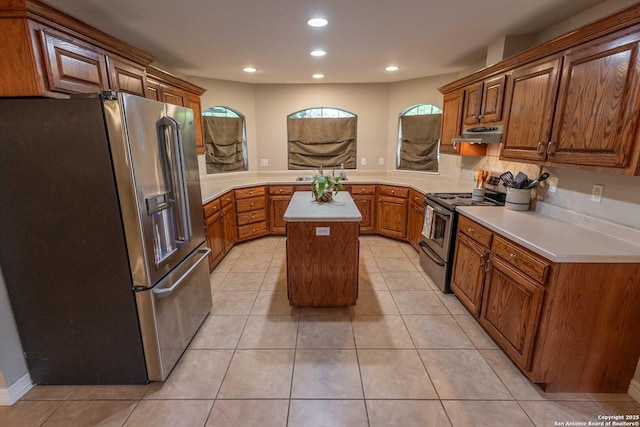 633 Sunrise Ave, Uvalde, TX 78801 - kitchen with stainless steel appliances, a kitchen island, light countertops, brown cabinets, and under cabinet range hood