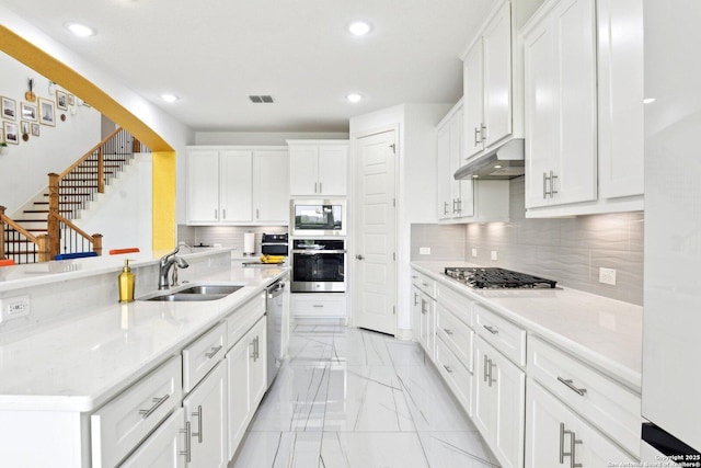 27118 Dana Creek Dr, Boerne, TX 78015 - kitchen with appliances with stainless steel finishes, light marble finish floors, a sink, under cabinet range hood, and recessed lighting