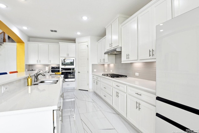 27118 Dana Creek Dr, Boerne, TX 78015 - kitchen with stainless steel appliances, under cabinet range hood, light marble finish flooring, a sink, and recessed lighting