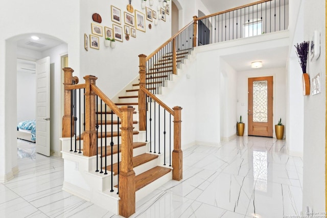 27118 Dana Creek Dr, Boerne, TX 78015 - entryway with arched walkways, a towering ceiling, stairs, and baseboards