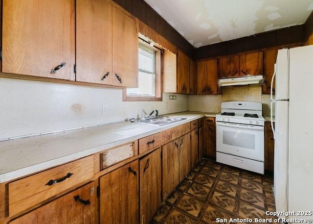 36 County Road 346c, Shiner, TX 77984 - kitchen featuring white appliances, under cabinet range hood, light countertops, a sink, and brown cabinetry
