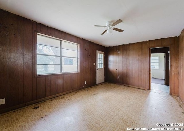36 County Road 346c, Shiner, TX 77984 - unfurnished room with a ceiling fan, wood walls, parquet flooring, and baseboards