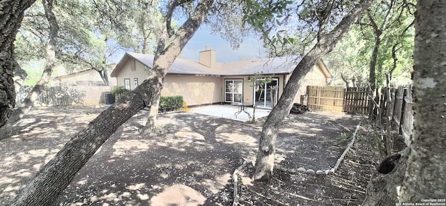 6115 Calderwood St, San Antonio, TX 78249 - rear view of house featuring a chimney, a patio area, and central AC unit