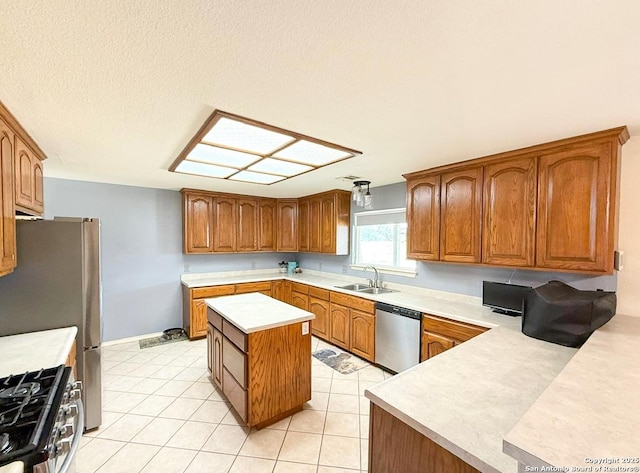 1185 County Road 7718, Devine, TX 78016 - kitchen with appliances with stainless steel finishes, a sink, light countertops, brown cabinets, and baseboards