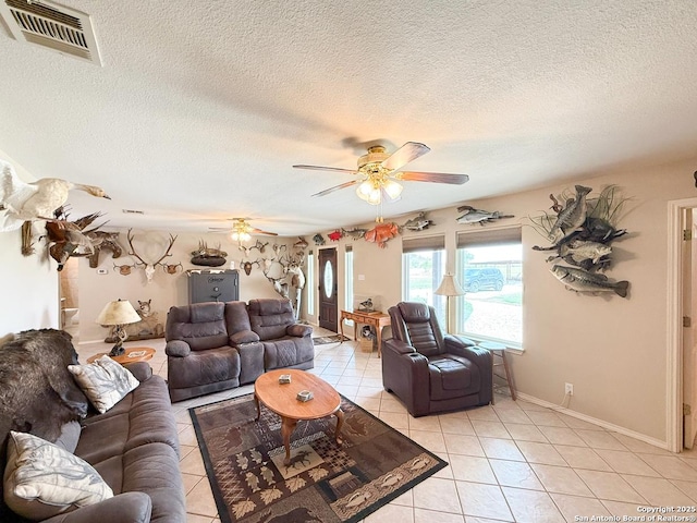 1185 County Road 7718, Devine, TX 78016 - living area with light tile patterned floors, ceiling fan, a textured ceiling, and baseboards