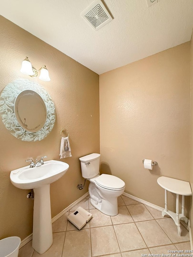 1185 County Road 7718, Devine, TX 78016 - half bathroom featuring toilet, tile patterned flooring, and a textured ceiling