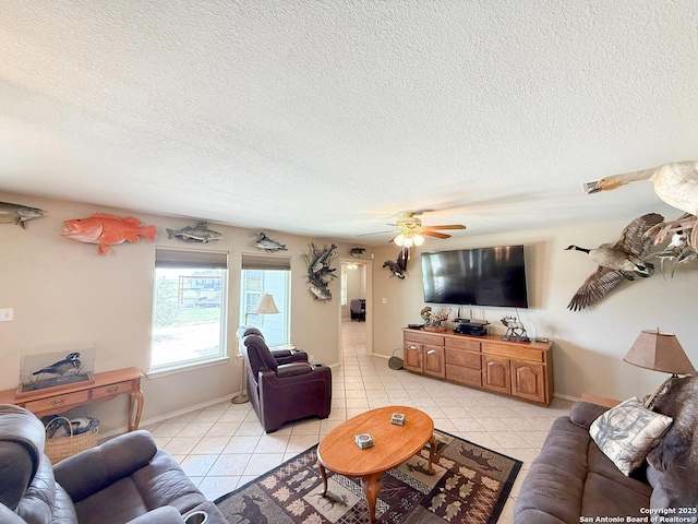 1185 County Road 7718, Devine, TX 78016 - living room featuring light tile patterned floors, a textured ceiling, baseboards, and a ceiling fan