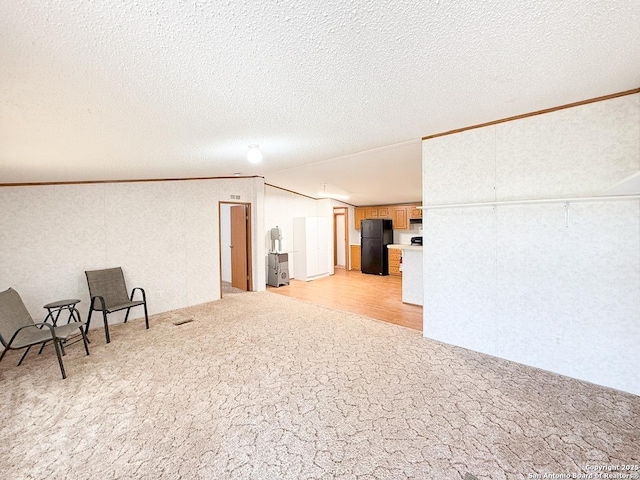 1185 County Road 7718, Devine, TX 78016 - below grade area featuring freestanding refrigerator, light carpet, crown molding, and a textured ceiling