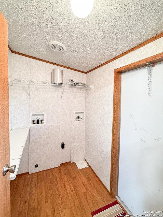 1185 County Road 7718, Devine, TX 78016 - washroom with ornamental molding, washer hookup, light wood-type flooring, and a textured ceiling