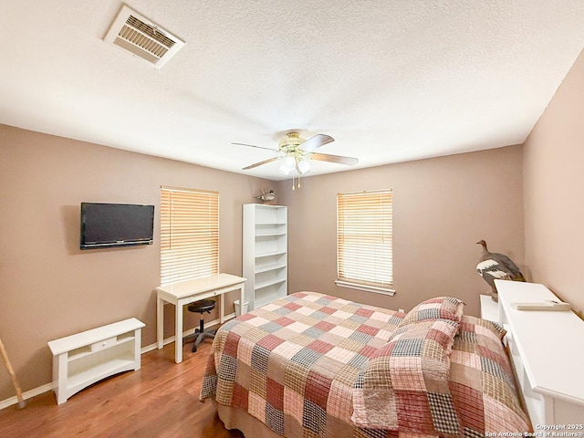 1185 County Road 7718, Devine, TX 78016 - bedroom featuring wood finished floors, baseboards, and a ceiling fan